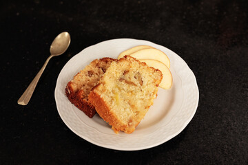 Close-up detail of white plate with two portions of apple pie and a dessert spoon.