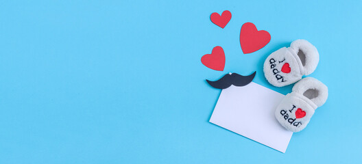 Children's shoes, an envelope and hearts with a mustache on blue.