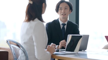 オフィスで打ち合わせをする男女