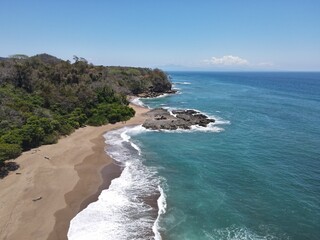 Fototapeta na wymiar Lush Tropical Beach Paradise with blue water, great waves and rock formations in Montezuma Nicoya Peninsula Costa Rica
