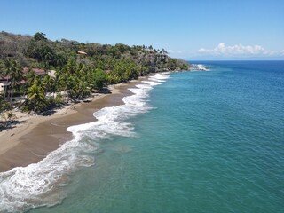 Fototapeta na wymiar Lush Tropical Beach Paradise with blue water, great waves and rock formations in Montezuma Nicoya Peninsula Costa Rica