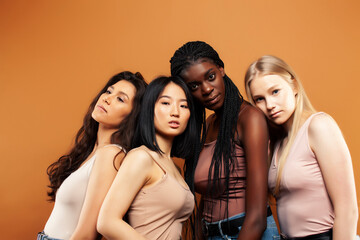 Fototapeta premium young pretty asian, caucasian, afro woman posing cheerful together on brown background, lifestyle diverse nationality people concept