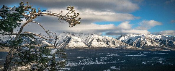 Snowy winter mountain range in Banff National Park in Alberta Canada on sunny day with blue sky.