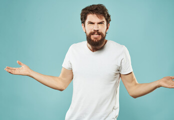 Cute man on a blue background gestures with his hands stress Scream irritability outrage