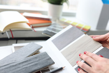 Woman choosing color of laminate board in design studio closeup