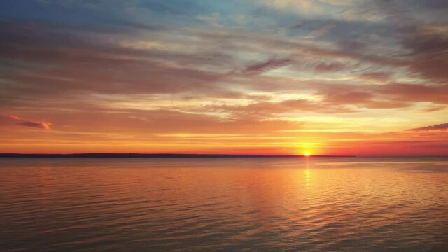 Beautiful seascape. Calm sea and colorful sunset water reflection at sunset. Nature video landscape.