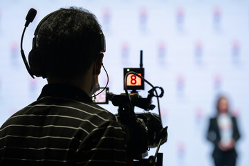 Asian man Videographer in backside are shooing and recording video in Speech event on the stage.