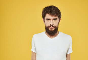 Obraz premium Portrait of a sad man on a yellow background cropped view of a white t-shirt