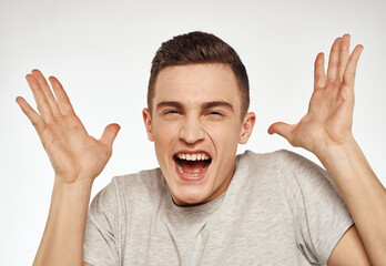 cheerful emotional man gesturing with his hands close-up light background
