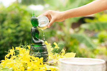 Sprinkle water onto a Buddha Statue in Songkran Festival and Thailand Holiday.