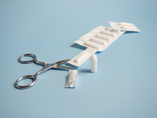 Suppository for anal or vaginal use on a blue background. Candles for the treatment of hemorrhoids,...
