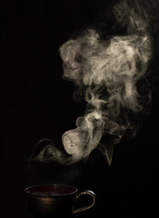 hot steaming hot tea on black background