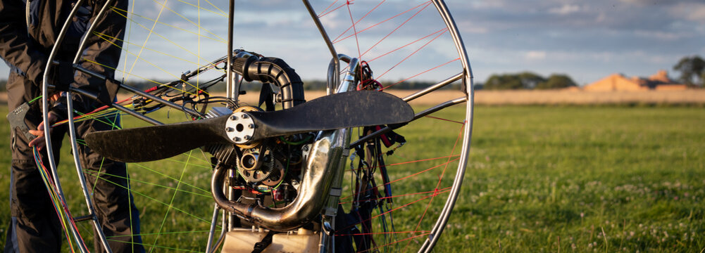 The pilot is preparing for flights a personal paralet with a gasoline engine. Paragliding for individual paragliding flights. Preparation for wing flight. Extreme sports. Small aircraft. Wide view