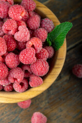 Fresh raspberry in wooden bowl. The berry is rich in vitamins.