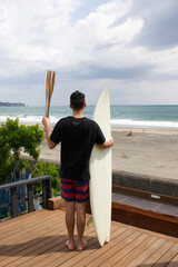 Man with a torch used in large sporting event and surfboard, close to surfing venue in Chiba Japan.