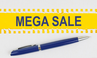 On the table are two sheets from a notebook and a pen on a yellow background written - MEGA SALE