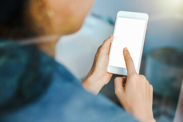 A woman shopping online on her sofa at home with a smartphone using and tap the screen to verify the identity. Concept about business. over shoulder shot