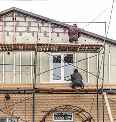 Naklejka premium Installation of siding on the walls of the house