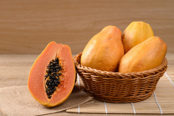 Ripe papaya fruit in a basket on wooden background, Tropical fruit