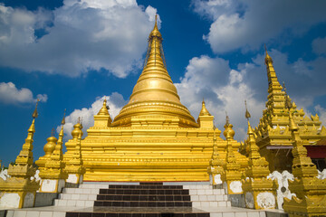 One of the golden stupas of the Buddhist temple Kuthodaw Pagoda against the background of the...