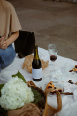 Fototapeta na wymiar still life with wine. picnic in the city. a glass of red wine on a white blanket