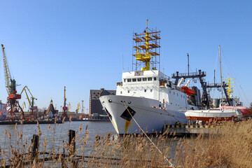 Kaliningrad commercial port. Fishing trawler on the Pregolya river at the pier. There are cranes on the shore