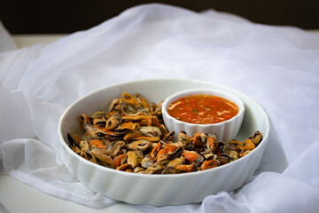 Poached mussels with seafood sauce in white plate