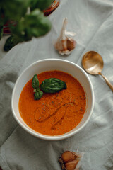lentil soup with a leaf of basil. cream soup in a white bowl. tomato soup. red cream soup.
