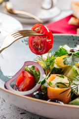 Closeup on eating fresh gourmet greek salad in a bowl