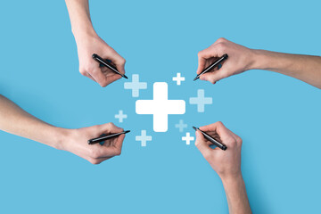 Several, four hands draw a plus icon with a marker.Plus sign virtual means to offer positive thing...