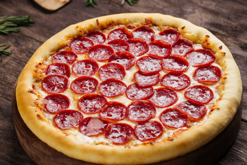 Fresh baked pepeproni pizza on the wooden background