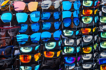  Sunglasses hang on a stand for sale. Large selection of sun protection products.