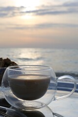 cup of coffee on the beach in a sunrise