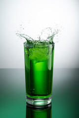 tall transparent glass with green tarragon lemonade on a light background