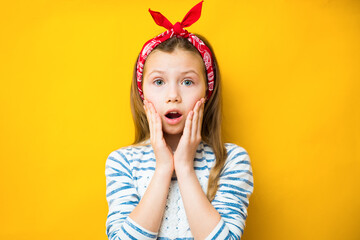 Surprised child girl on yellow background. Menstrual period for the first time concept