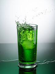 tall transparent glass with green tarragon lemonade on a light background