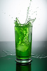 tall transparent glass with green tarragon lemonade on a light background