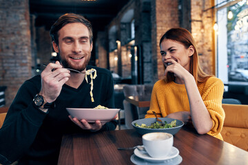 cheerful man and woman sitting in a cafe communicating emotions