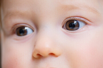 Naklejka premium Big eyes of a small beautiful child close up