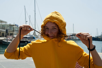 Smiling young woman in yellow hoodie 