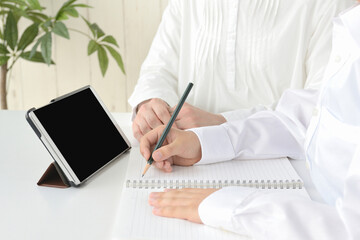 タブレットを使って学習する小学生と母親,