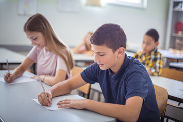 School children writing in class.