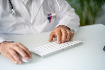 Close up of a Doctor in white coat working telematically in his office