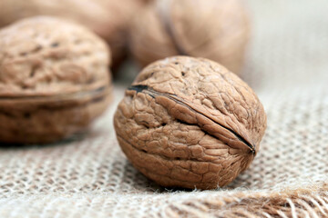 Close-up walnuts lie on a burlap.