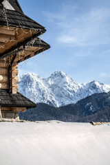 snow, wooden chalet and Giewont mountain in Kościelisko, Poland, Tatra Mountains. Winter view.