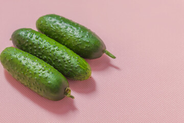 On the left side of the photo are three fresh cucumbers