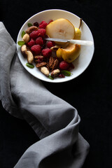 WHITE PLATE OF ORGANIC FRUIT & NUTS WITH VINTAGE SMALL MOTHER OF PEARL HANDLED KNIFE GREY LINEN...