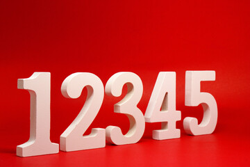 Counting numbers ( 1 2 3 4 5 ) white number wooden on Red Background with Copy Space - One Two...