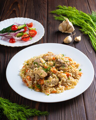Pilaf with meat and salad in white plates on a wooden table. Photo for the menu of a restaurant, cafe, canteen. 