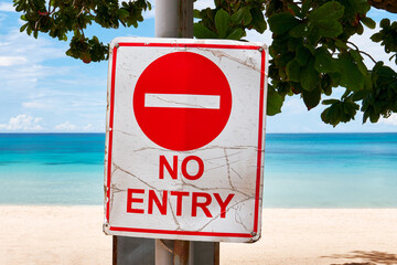 Red colored no entry road sign attached to a pole in front of the White Beach and the blue sea on Boracay Island, Aklan Province, Philippines, Asia